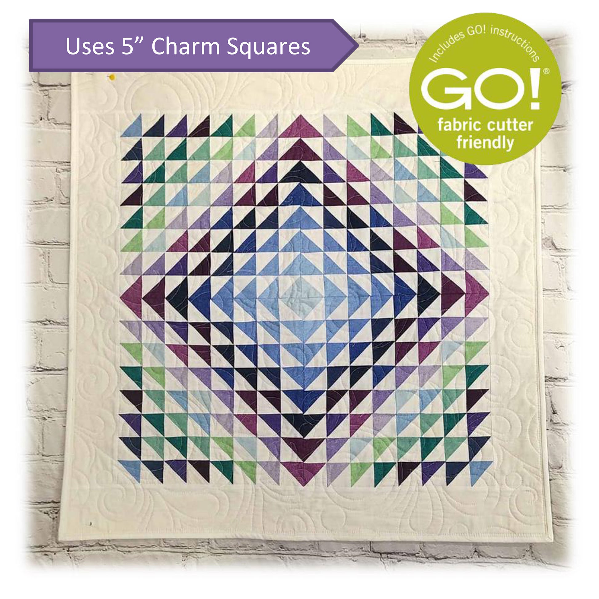 Colorful quilt with purple and green triangle design with note about this pattern being Accuquilt GO! fabric cutter friendly and that it uses 5-inch charm squares.