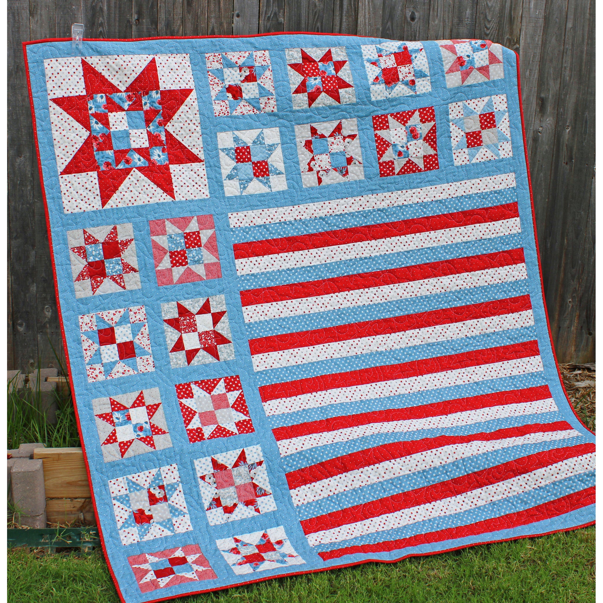 A patriotic quilt showcasing red, white, and blue ohio stars along side red, white and blue stripes. Perfect Americana quilt without being an actual flag.