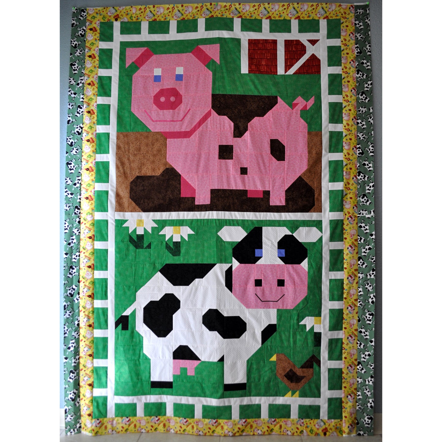 Adorable cow and pick quilt with top of pig smiling in a mud puddle and bottom of cow in grassy field.