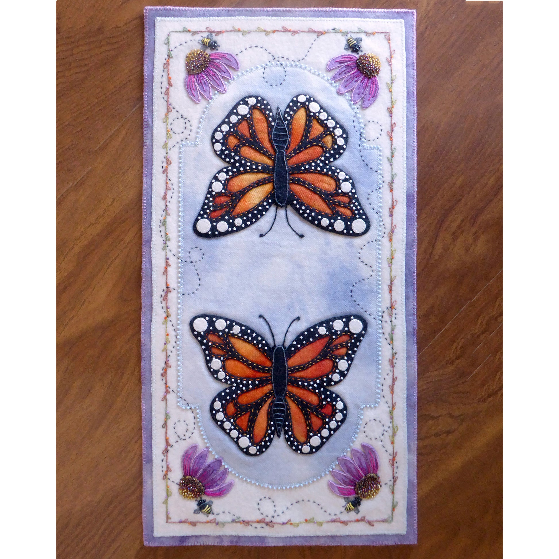 A table runner adorned with two delicate butterflies fluttering gracefully with flowers and bees.
