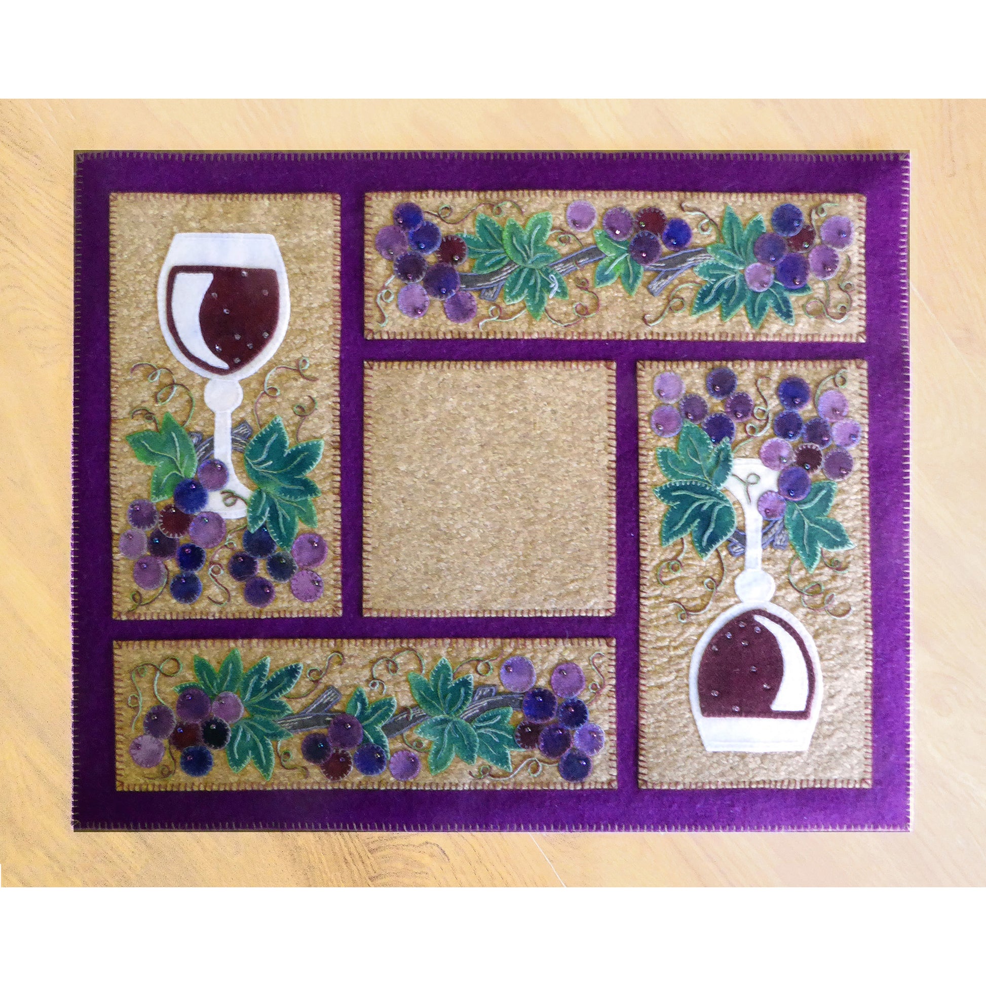 Purple and gold placemat with grapes and wine.