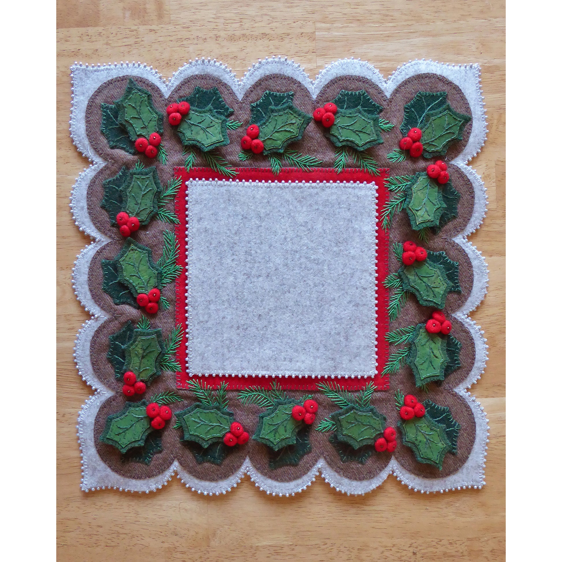 A festive table runner with holly leaves, perfect for adding a touch of Christmas cheer to your dining table.