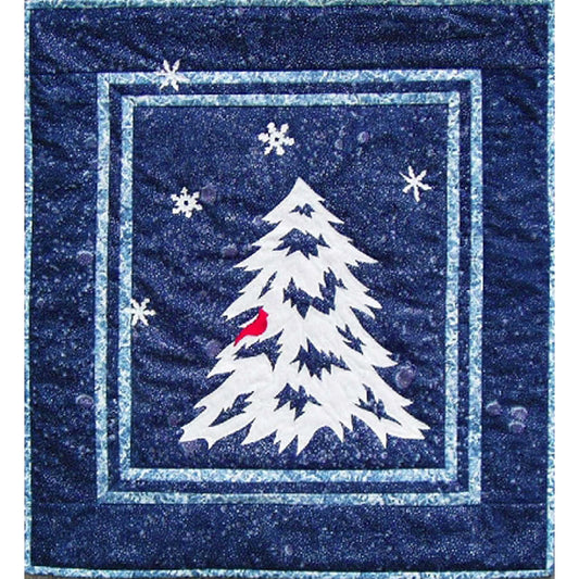 Quilt of a white evergreen tree/outline with snowflakes on a blue background with a red bird on one limb.