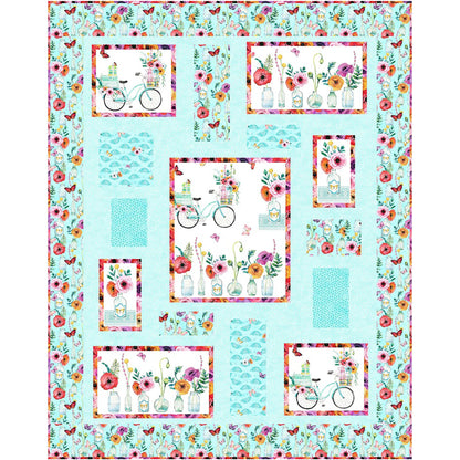 Colorful quilt with flowers and bicycles in pretty pinks and blues with a blue background.