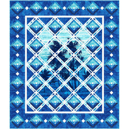 Serene quilt showcasing palm trees against a serene blue sky cut up so looks like seen through diamond panes with sunset log cabin blocks on the sides. In shades of blue