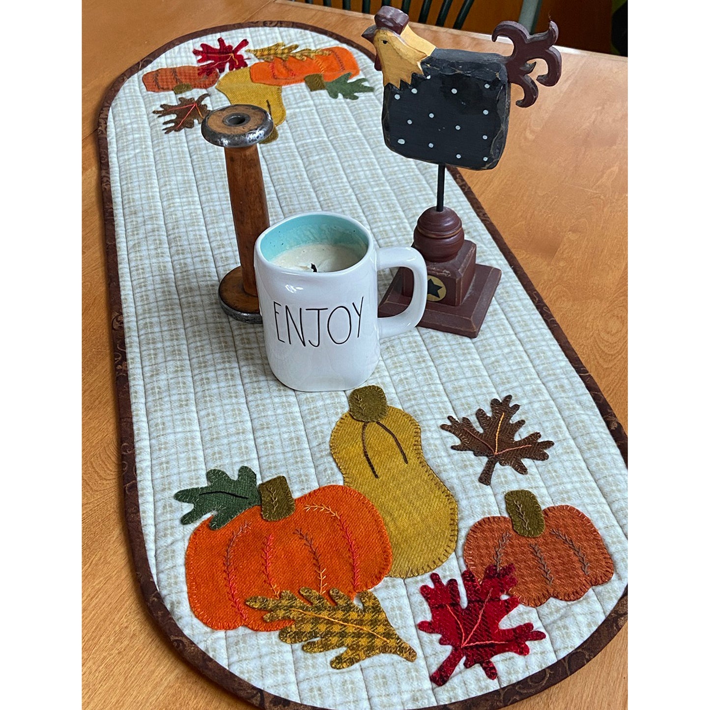 Autumn-themed table runner adorned with pumpkins and leaves.